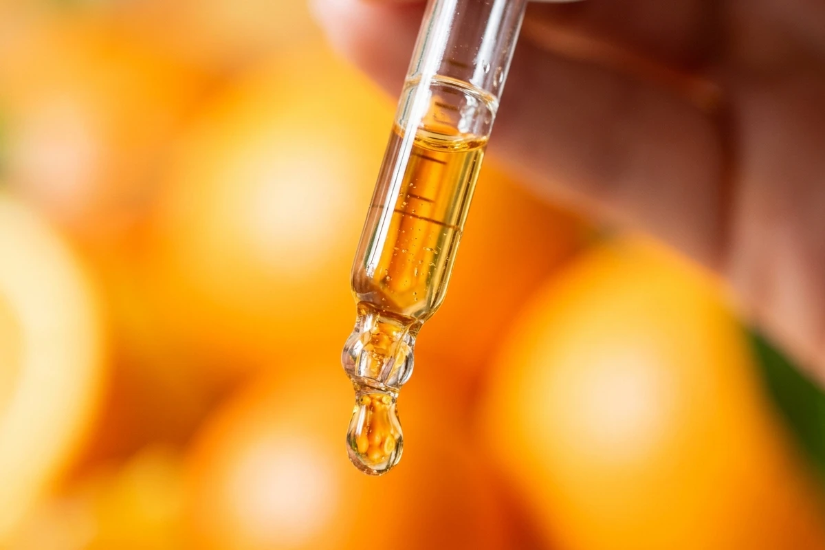 Glass dropper dispensing a pure golden drop of cold pressed virgin Marula oil